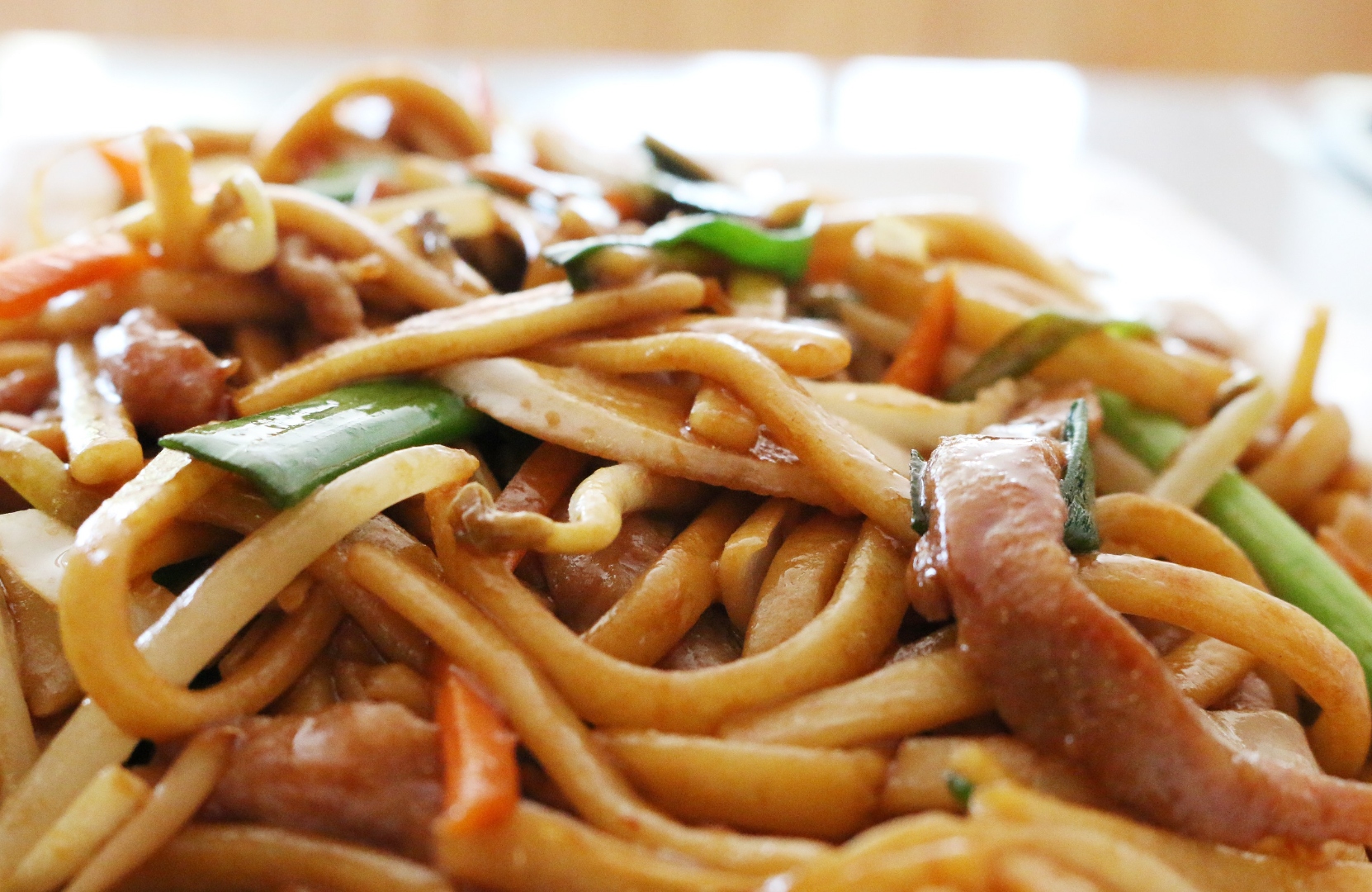 Pork lo mein with noodles lifted by chopsticks